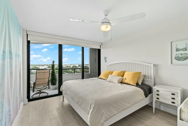 a bedroom with a large bed and a large window with outer view