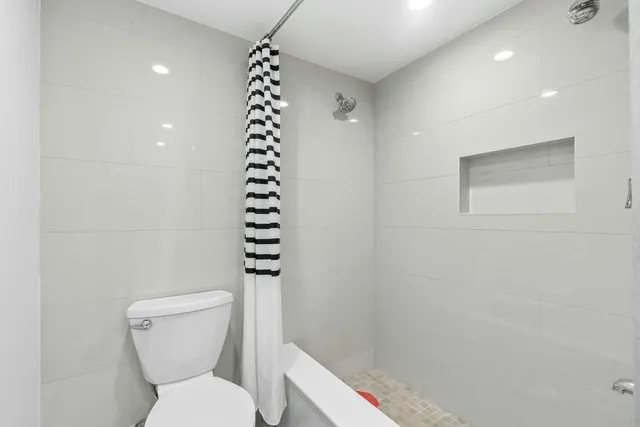 a bathroom with a toilet and a shower