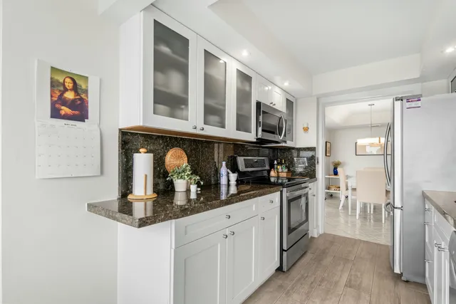 a kitchen with stainless steel appliances granite countertop a stove and cabinets