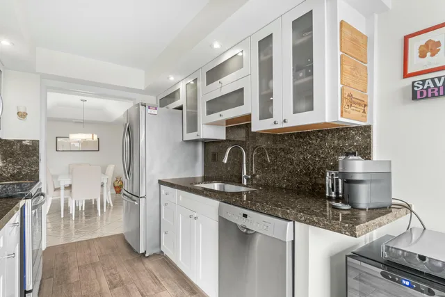 a kitchen with stainless steel appliances granite countertop a sink stove and cabinets