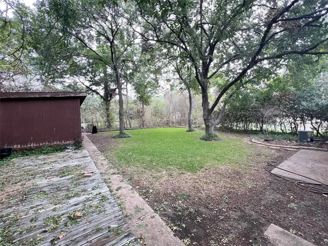 a view of a house with backyard and a tree