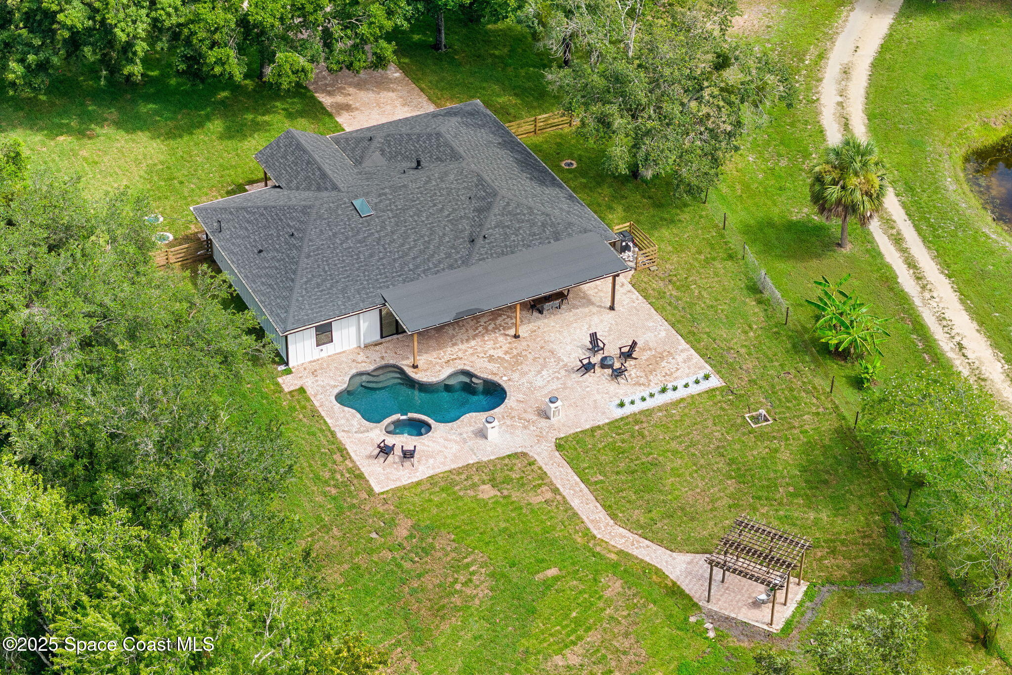 an aerial view of a house with a garden and swimming pool