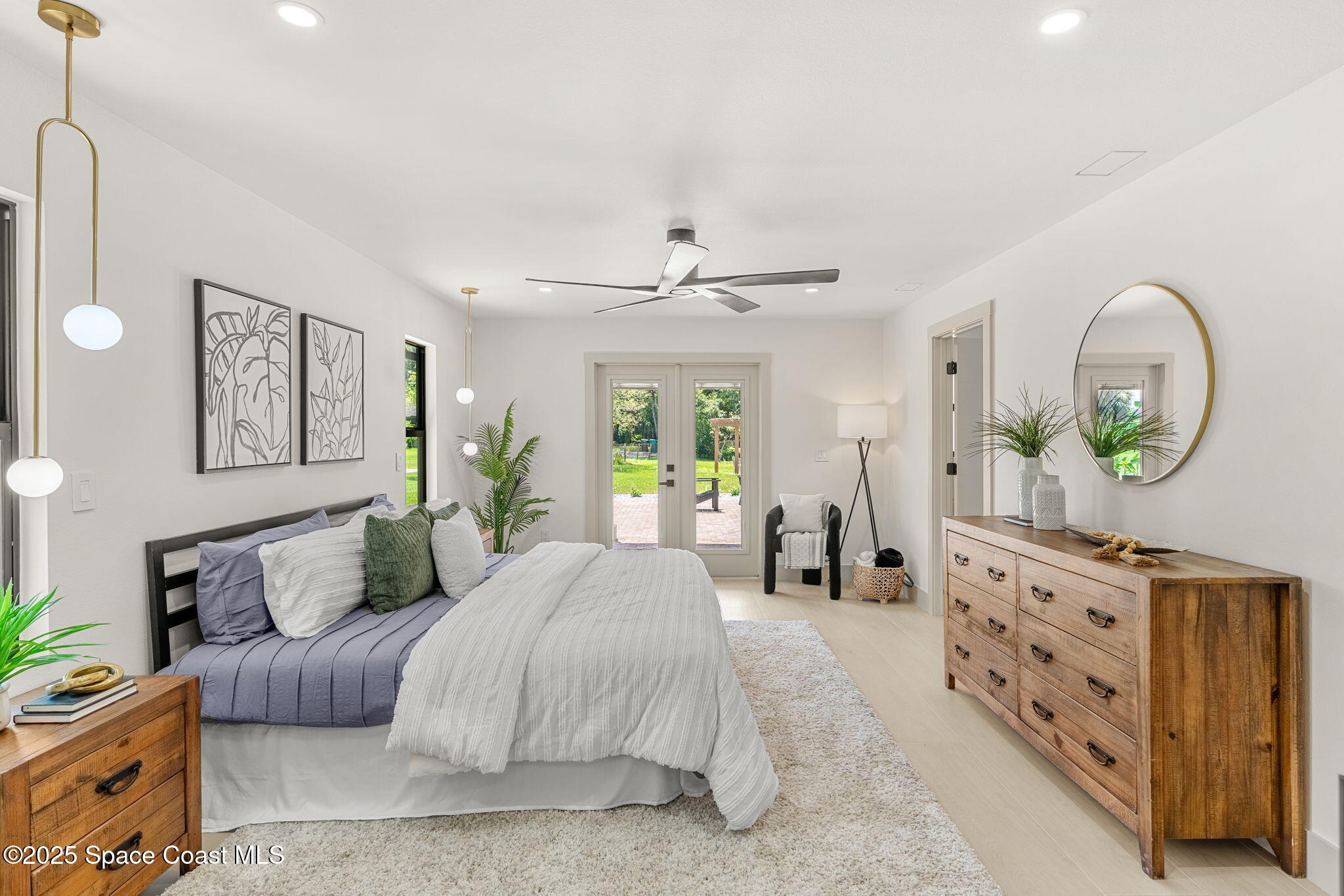 4313 Country Road Melbourne, FL 32934 - Photo 21 of 58 a spacious bedroom with a bed a mirror and a dresser