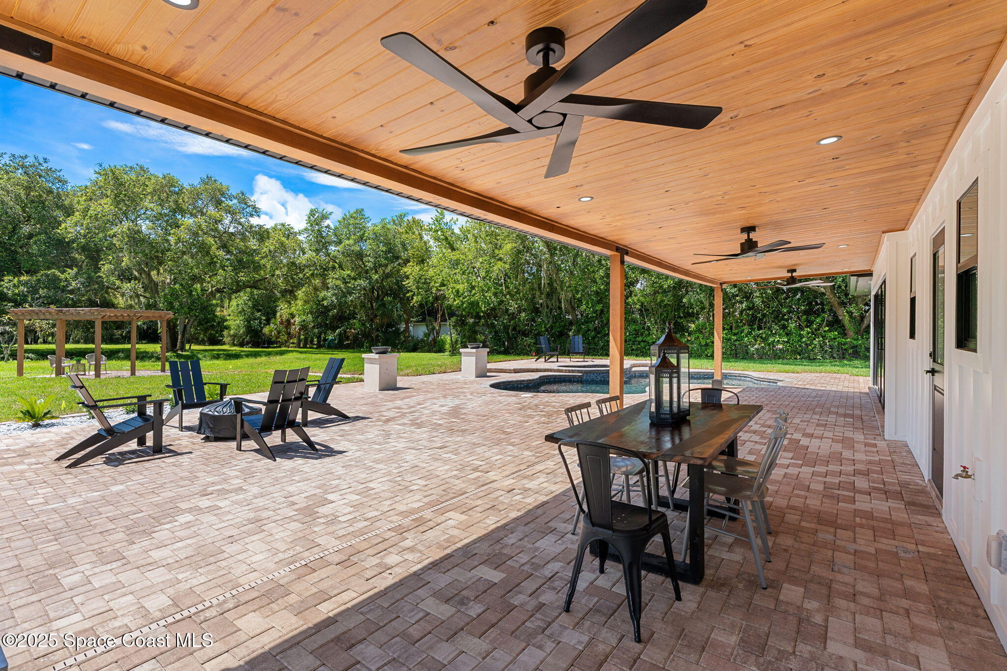 4313 Country Road Melbourne, FL 32934 - Photo 32 of 58 a view of a patio with a table chairs and a backyard