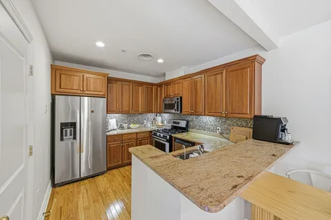 a kitchen with stainless steel appliances granite countertop a sink refrigerator and cabinets