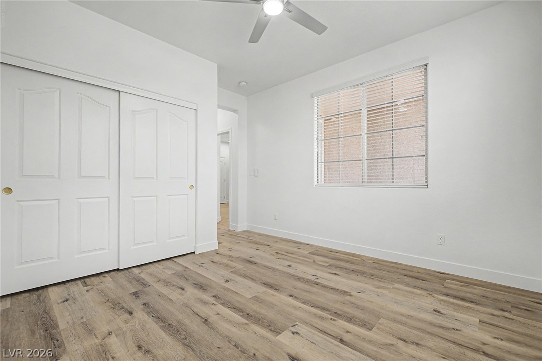 835 Entrada Ridge Avenue Henderson, NV 89012 - Photo 21 of 34 A well-lit bedroom features durable laminate flooring and a ceiling fan for comfort.