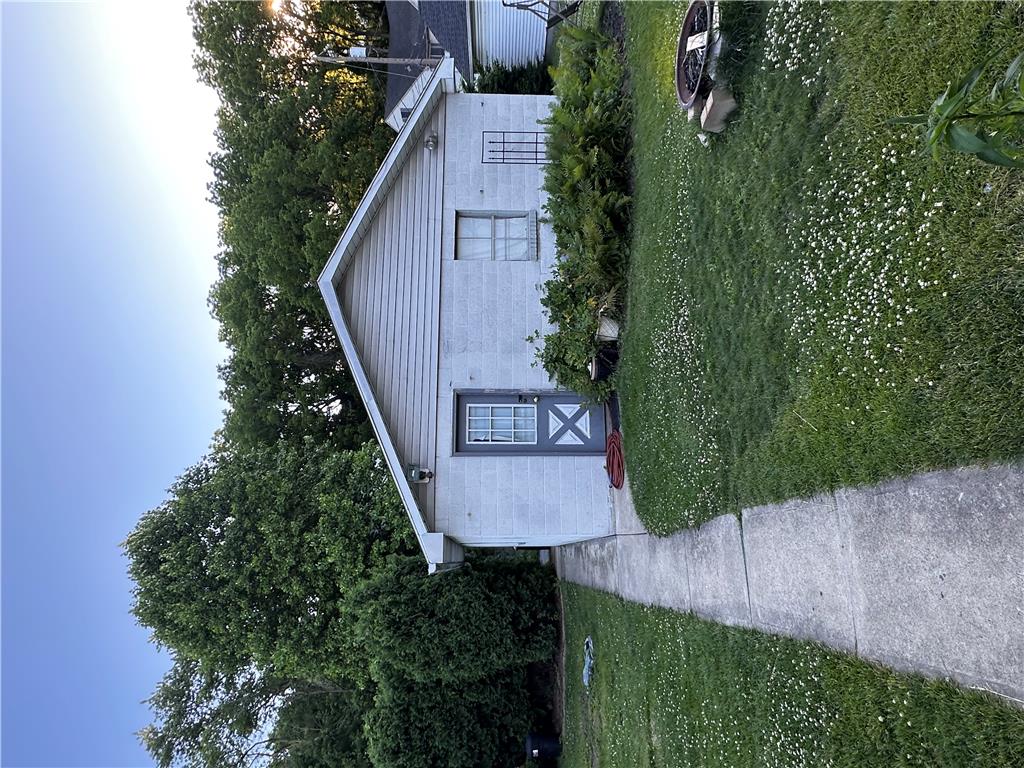 5128 3rd Street Whitehall, PA 18052 - Photo 8 of 26 A well-maintained side yard with a concrete pathway leads to this charming dwelling, offering green space and privacy.