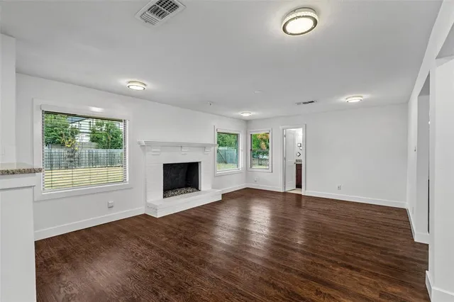 an empty room with wooden floor and fireplace