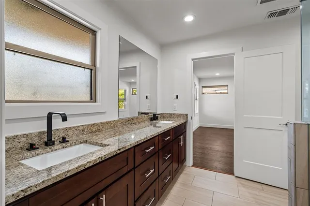 a bathroom with a granite countertop sink and a mirror
