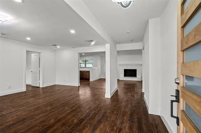 an empty room with wooden floor and fireplace