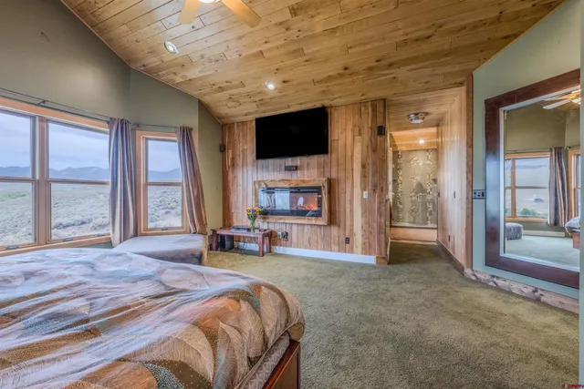 a spacious bedroom with a large bed and a flat screen tv