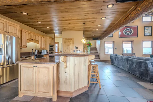 a kitchen with stainless steel appliances granite countertop a sink a stove and a refrigerator