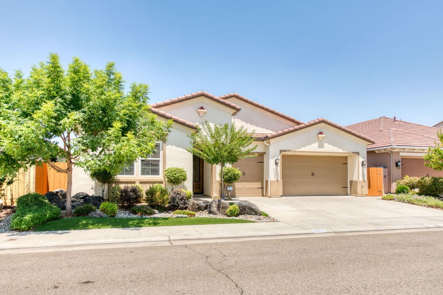 3301 Salem Avenue Clovis, CA 93619 - Photo 2 of 41 a front view of a house with a yard and garage