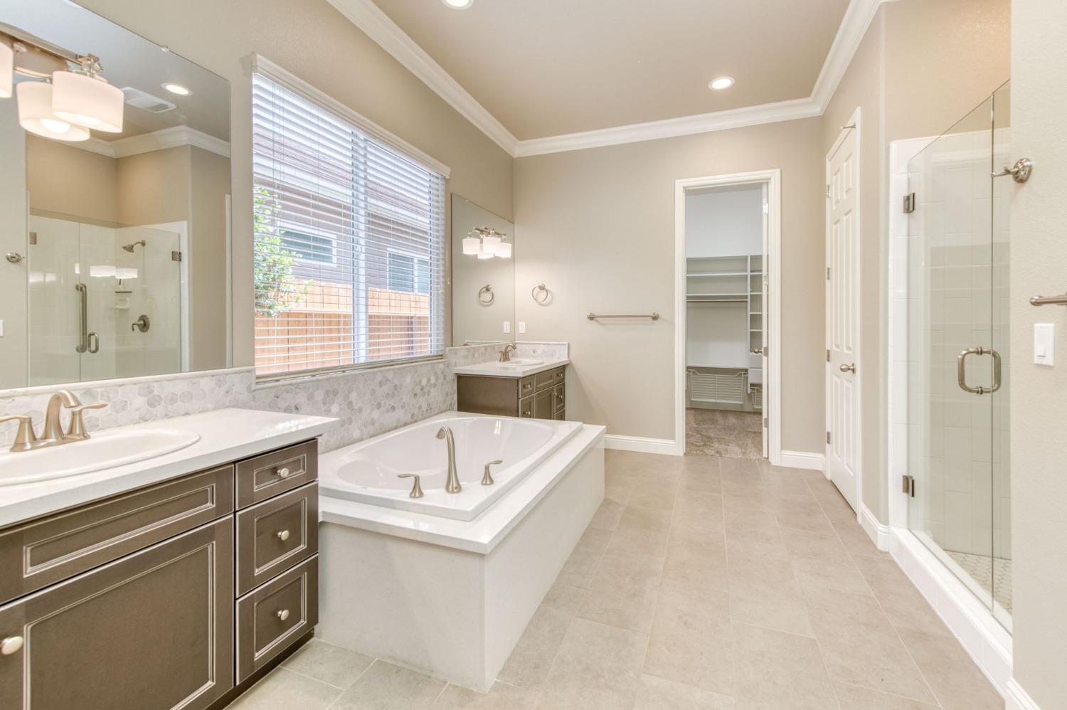 3301 Salem Avenue Clovis, CA 93619 - Photo 29 of 41 a bathroom with a granite countertop sink a large mirror and a bathtub