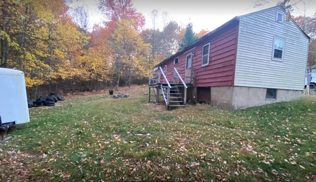a view of a house with a yard and sitting area