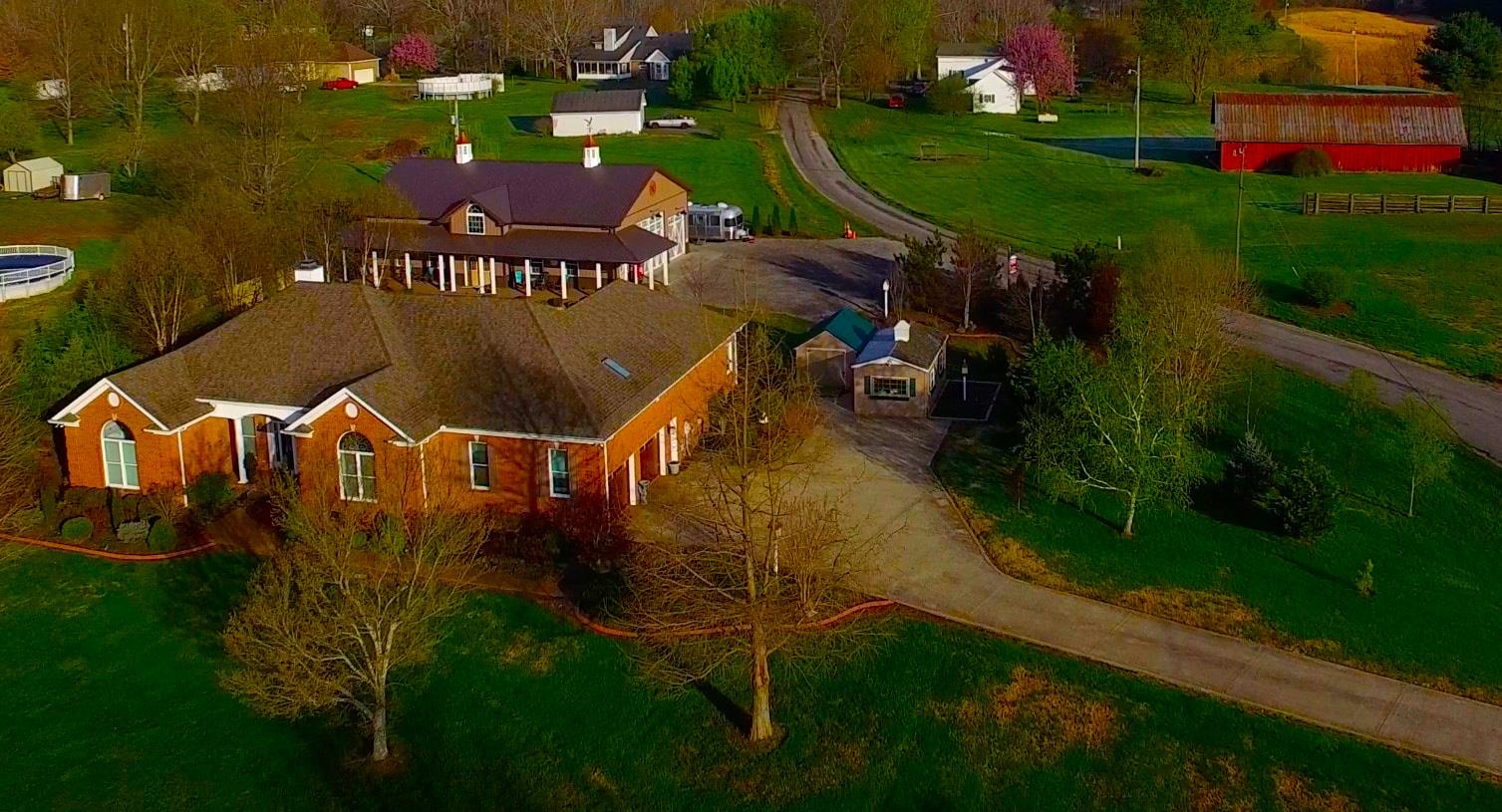 an aerial view of a house with pool garden and outdoor seating