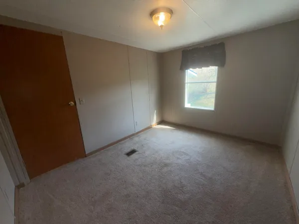 an empty room with windows and fireplace