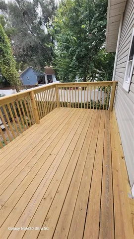 a balcony with wooden floor and fence