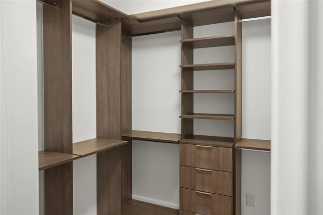 a view of walk in closet with empty racks