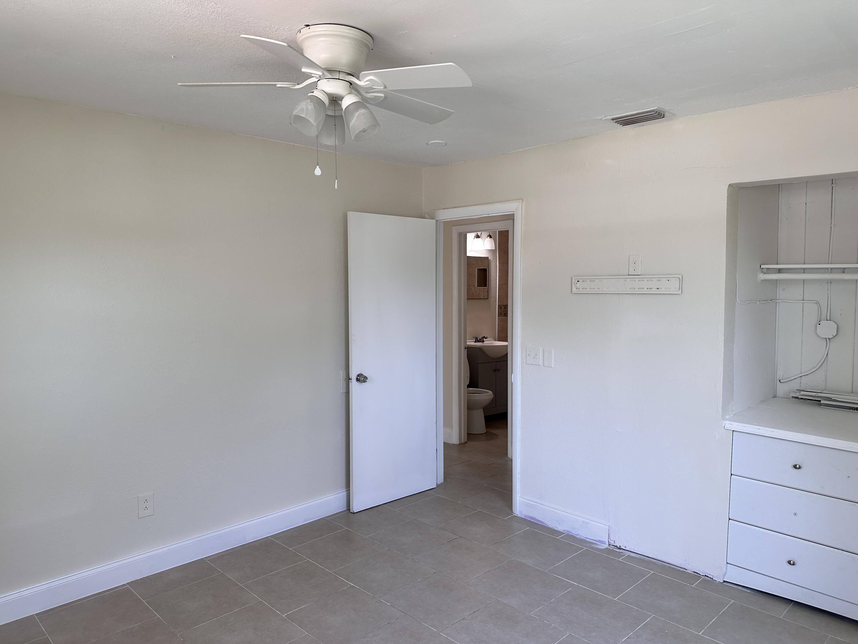 840 West 1st Street Riviera Beach, FL 33404 - Photo 12 of 22 a view of a livingroom with a ceiling fan and a bathroom