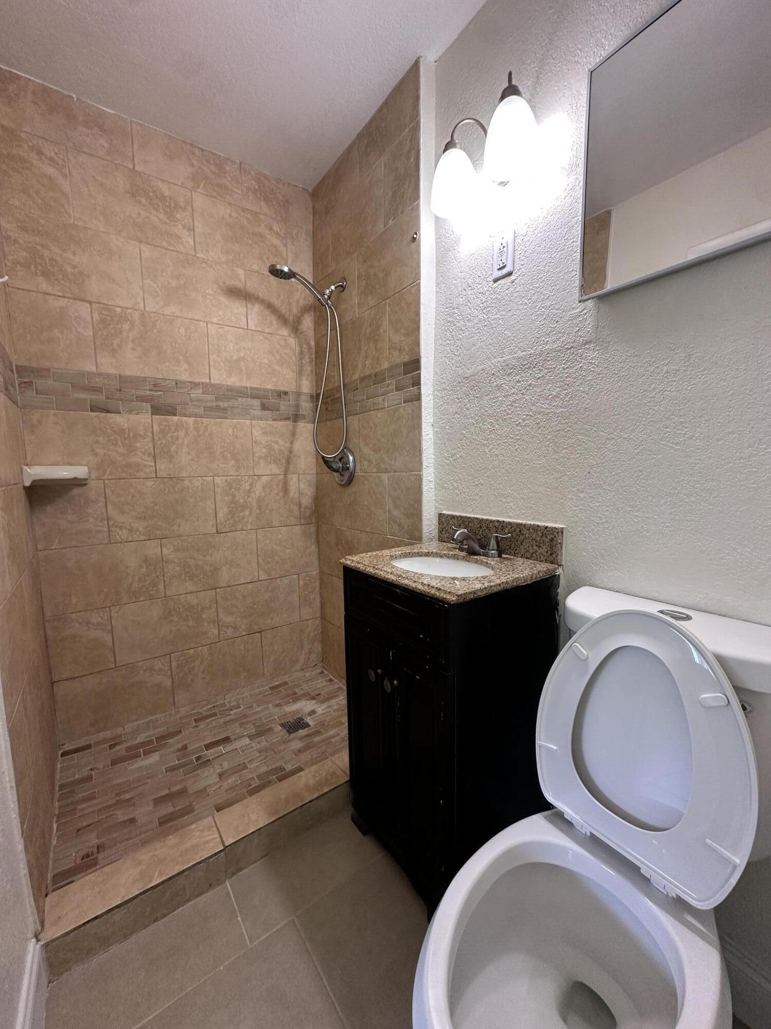 840 West 1st Street Riviera Beach, FL 33404 - Photo 17 of 22 a bathroom with a toilet a sink and mirror