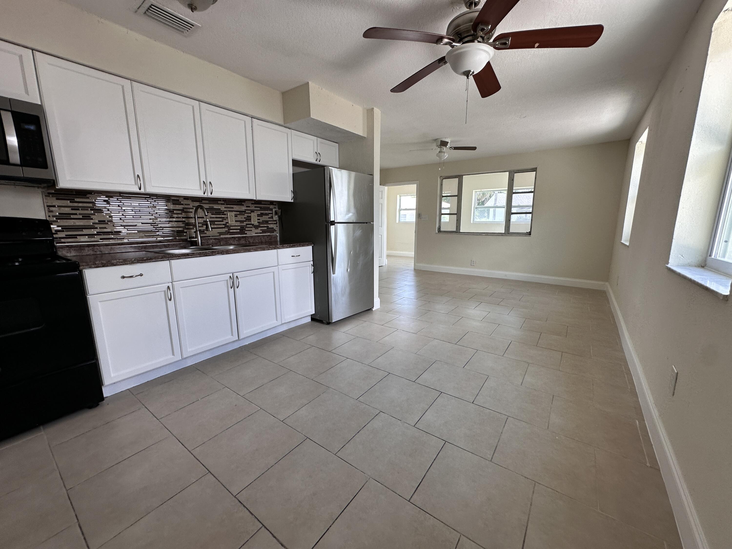 840 West 1st Street Riviera Beach, FL 33404 - Photo 5 of 22 a kitchen with granite countertop a refrigerator a sink and dishwasher