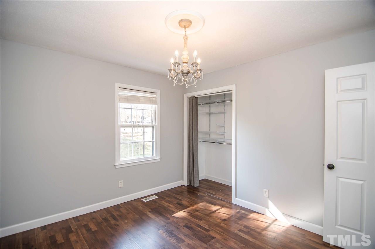 4804 Waybridge Court Raleigh, NC 27606 - Photo 22 of 30 an empty room with wooden floor chandelier and windows