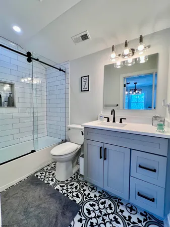a bathroom with a double vanity sink mirror and toilet