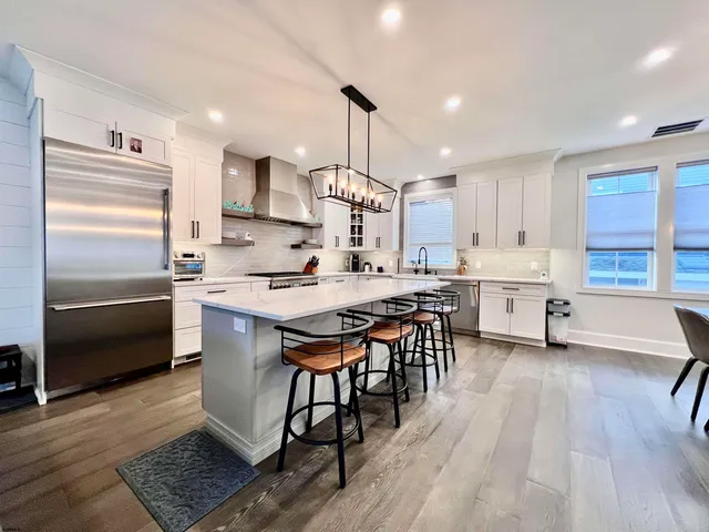 a kitchen with granite countertop a stove a sink and a refrigerator