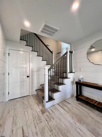 a view of entryway and hall with wooden floor