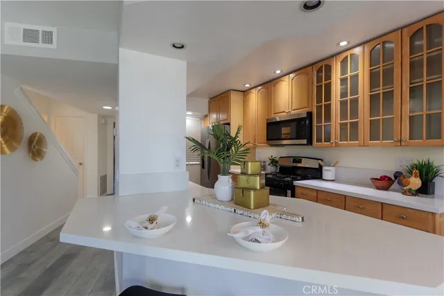 a kitchen with stainless steel appliances granite countertop a sink a stove and a refrigerator