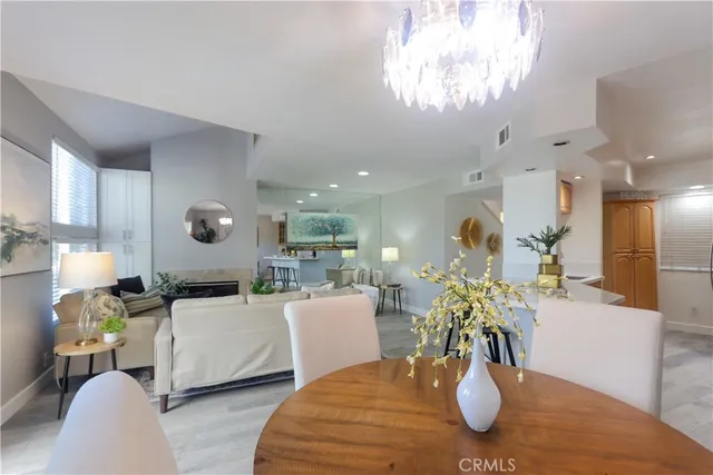 a view of a dining room with furniture a chandelier and wooden floor