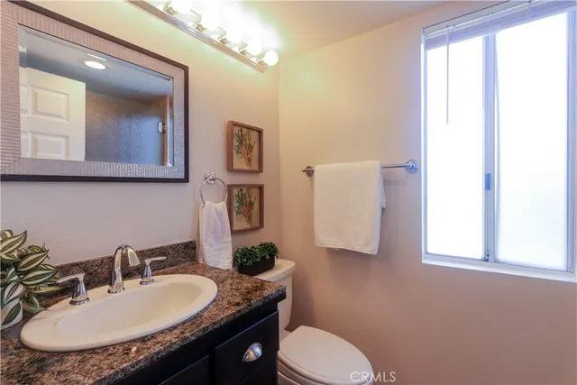 a bathroom with a granite countertop double vanity and a mirror
