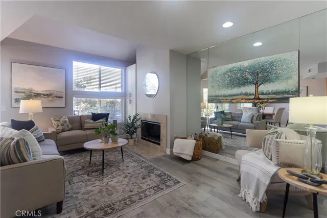 a living room with furniture a fireplace and a large mirror