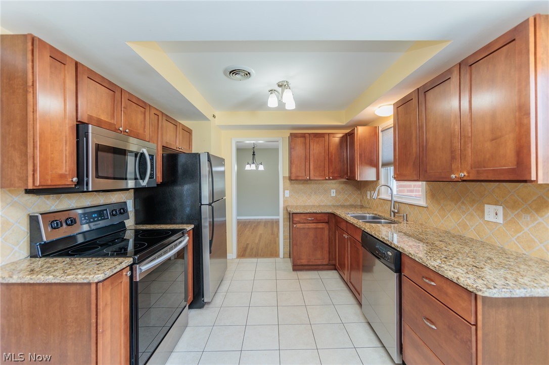 2444 Dysart Road Cleveland, OH 44118 - Photo 19 of 44 Kitchen with light tile flooring, tasteful backsplash, stainless steel appliances, and sink
