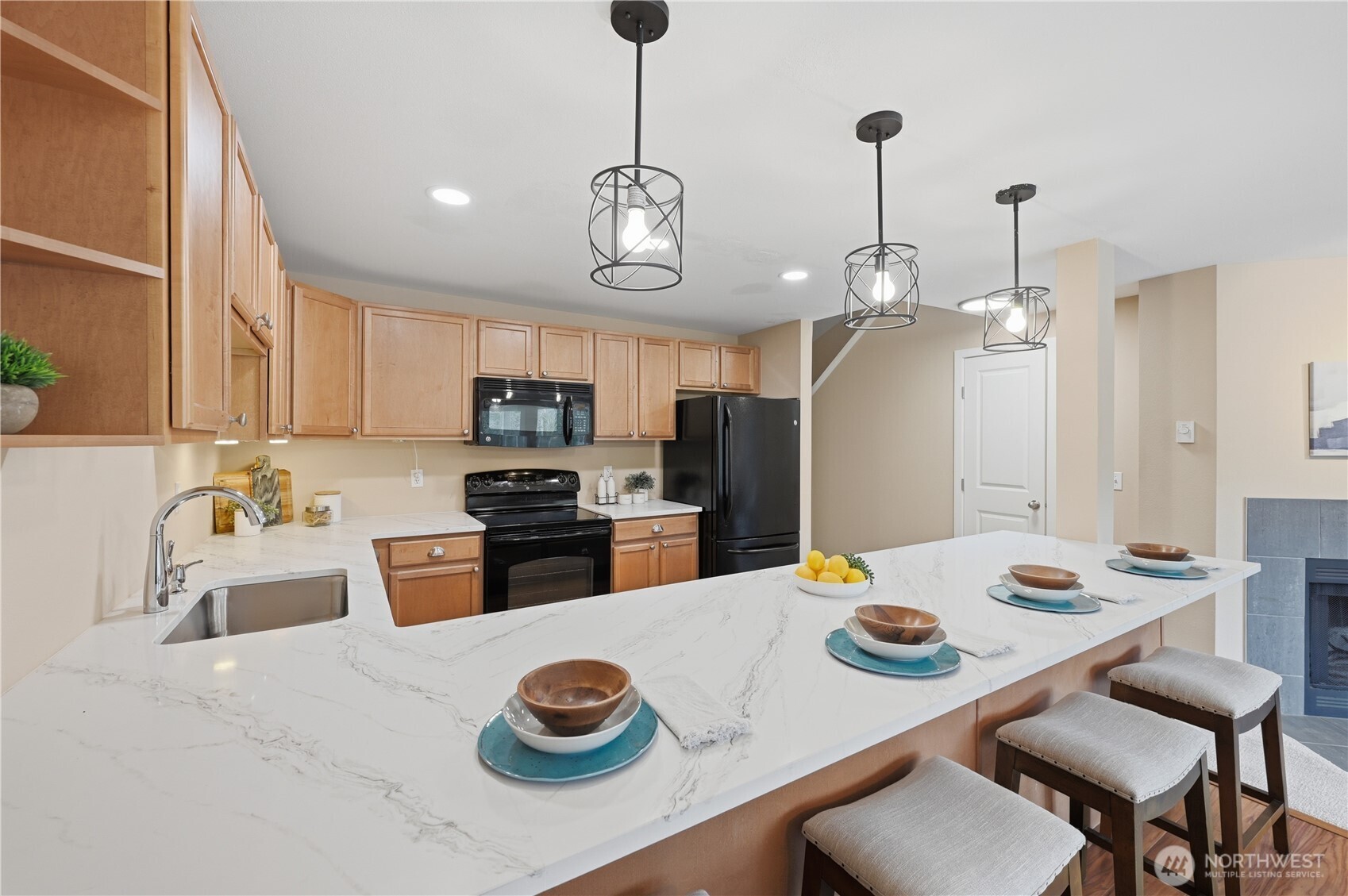 700 Front Street South, Unit E206 Issaquah, WA 98027 - Photo 6 of 32 a kitchen with stainless steel appliances wooden floor dining table and chairs