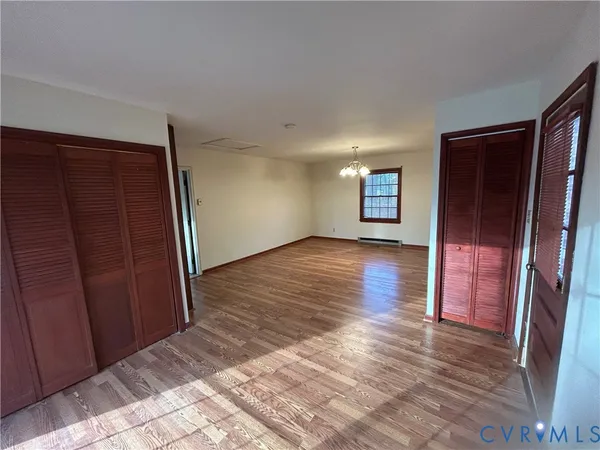 an empty room with wooden floor and entrance