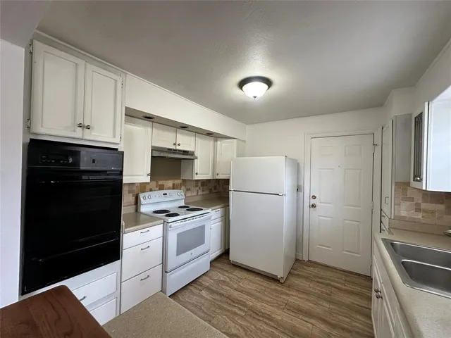 a kitchen with a refrigerator sink and cabinets