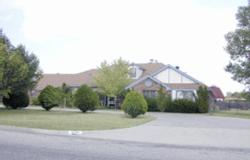 a view of a house with a yard and large trees