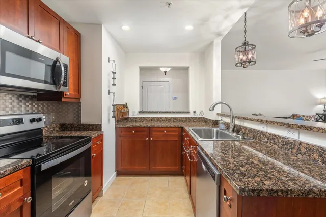 a kitchen with stainless steel appliances granite countertop a sink stove and cabinets