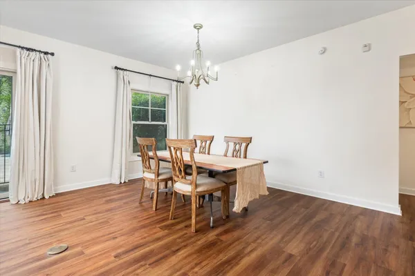 a dining room with furniture a chandelier and wooden floor