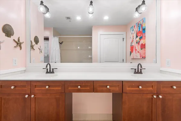 a bathroom with a sink a mirror a vanity and shower