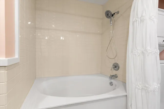 a bathroom with a bath tub with a shower