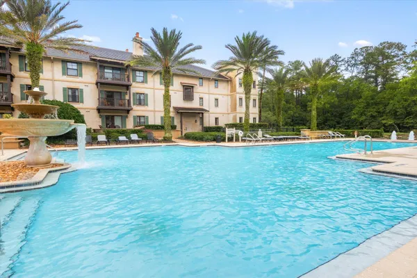 a view of a swimming pool with a yard and plants