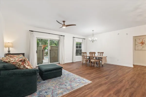a living room with furniture and a dining table with garden view