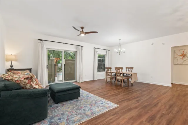 a living room with furniture and a dining table with garden view