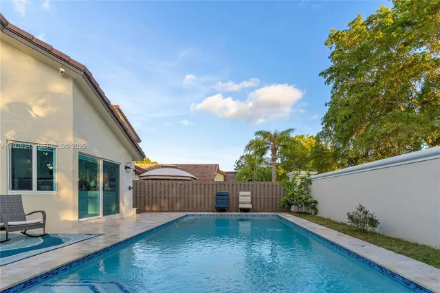 a view of backyard with potted plants and a large tree