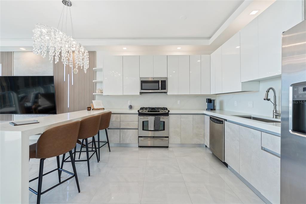 150 East Robinson Street, Unit 601 Orlando, FL 32801 - Photo 10 of 23 a kitchen with stainless steel appliances a stove a sink a microwave a refrigerator and cabinets