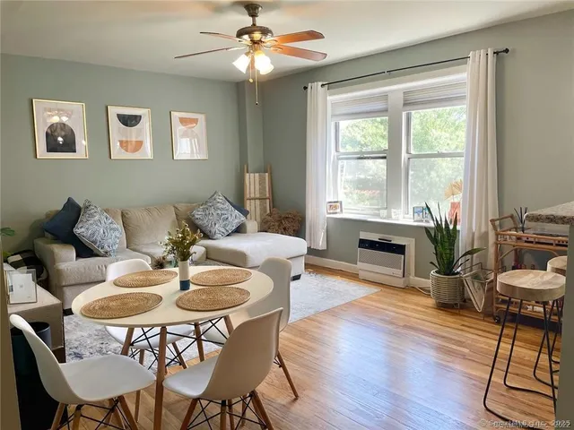 a dining room with furniture a chandelier and wooden floor