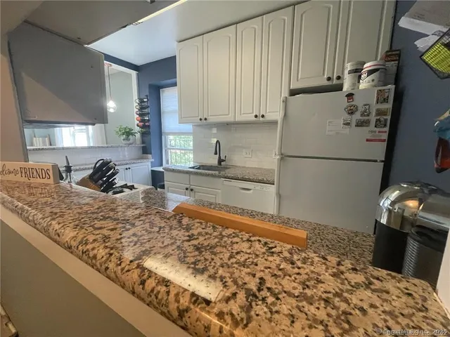 a kitchen with a sink refrigerator and cabinets